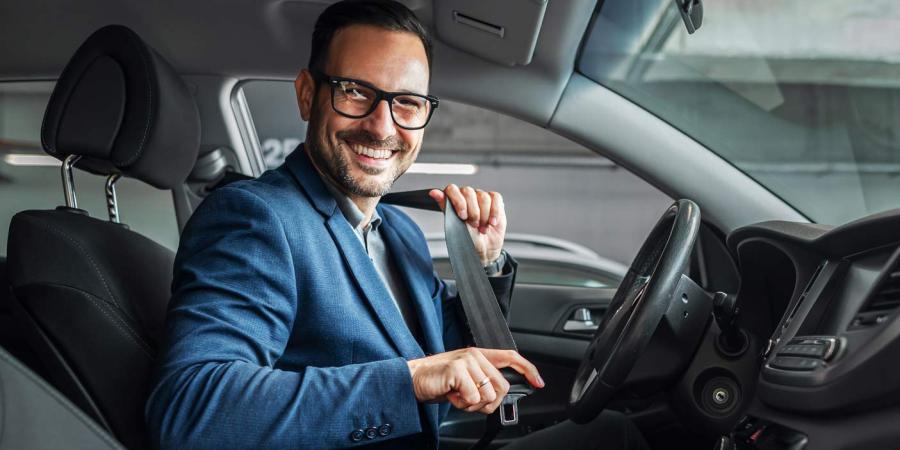 Un homme attachant sa ceinture de sécurité dans sa voiture
