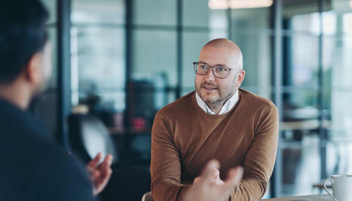 Deux hommes sont en train de discuter dans une salle de réunion