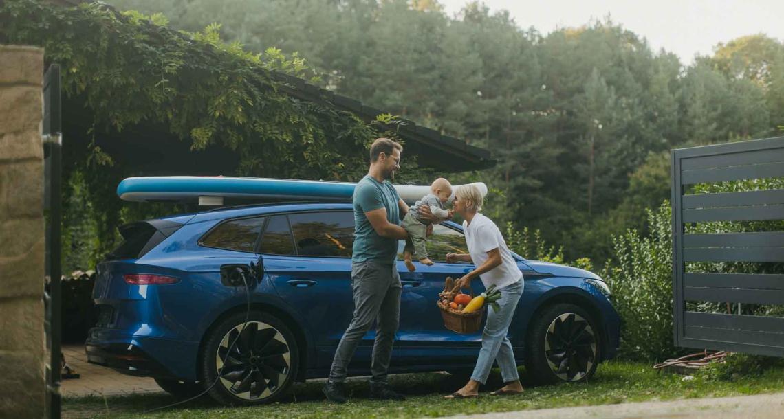 Une famille à coté d'une voiture bleue