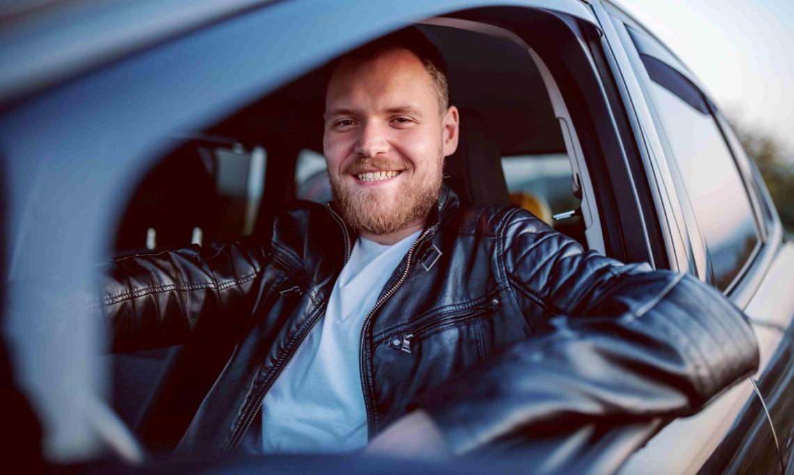 Man sitting in car smiling