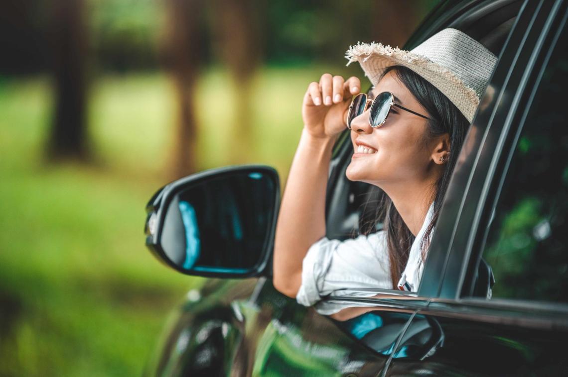 Woman sitting in car smiling