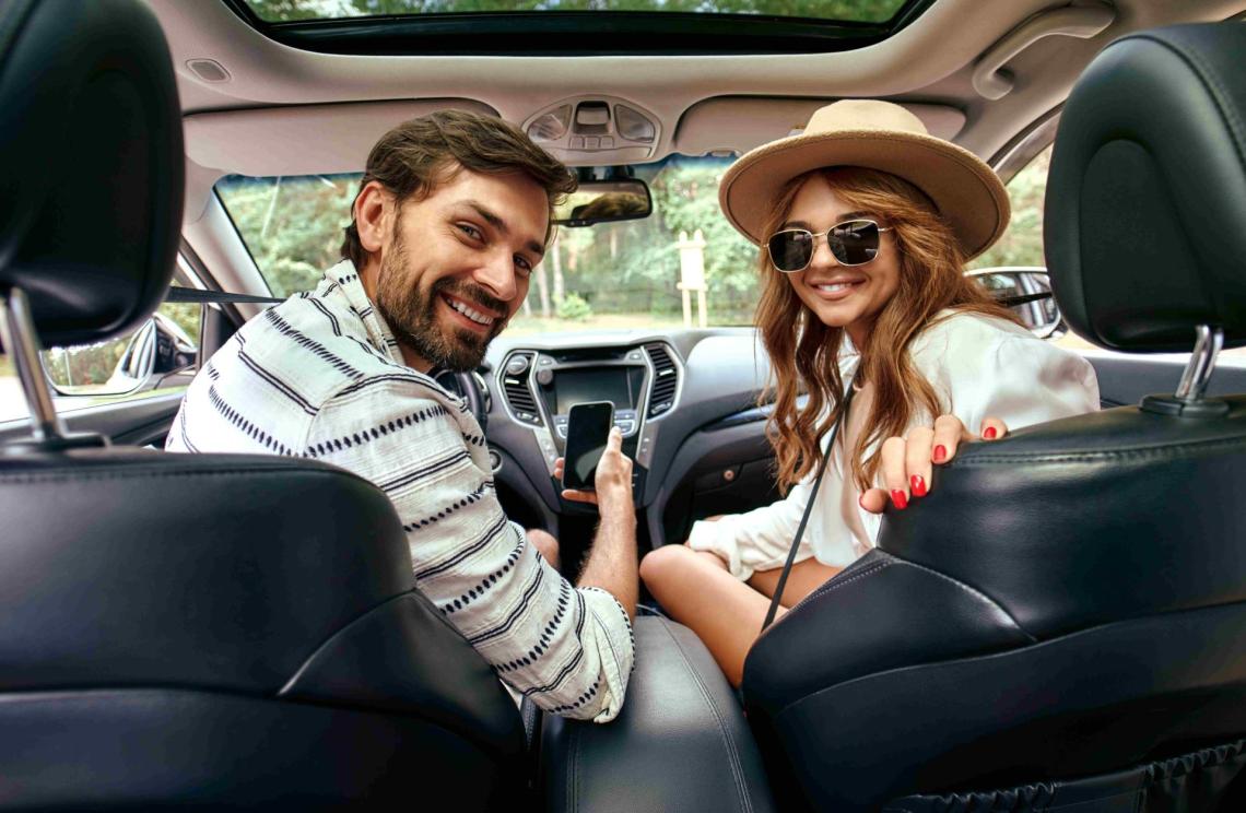 woman and man looking backwards in car
